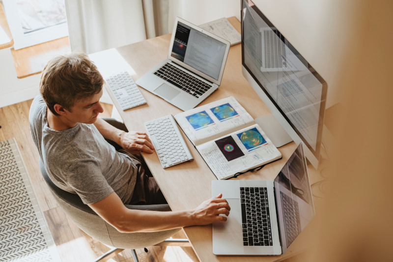 persona alla scrivania che lavora al computer per creare il piano editoriale blog per il suo business