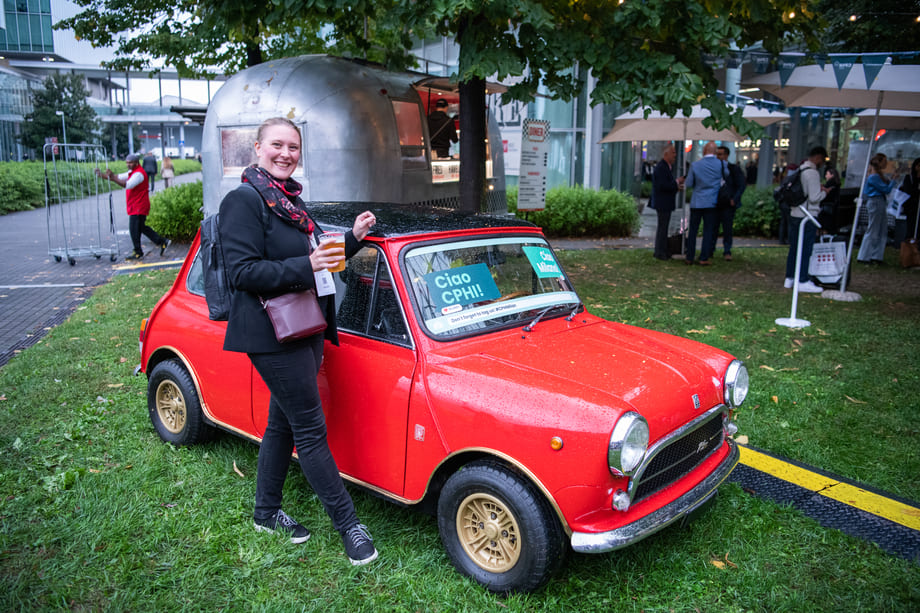 donna che si fa un selfie davanti alla mini cooper con il logo dell'evento